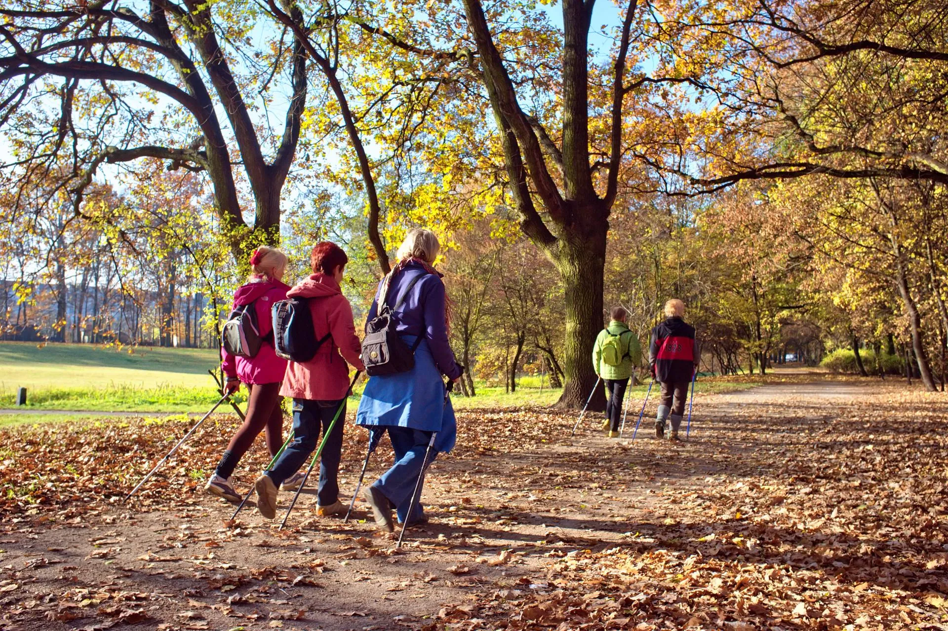 Riverside path with walkers spaced along the railing